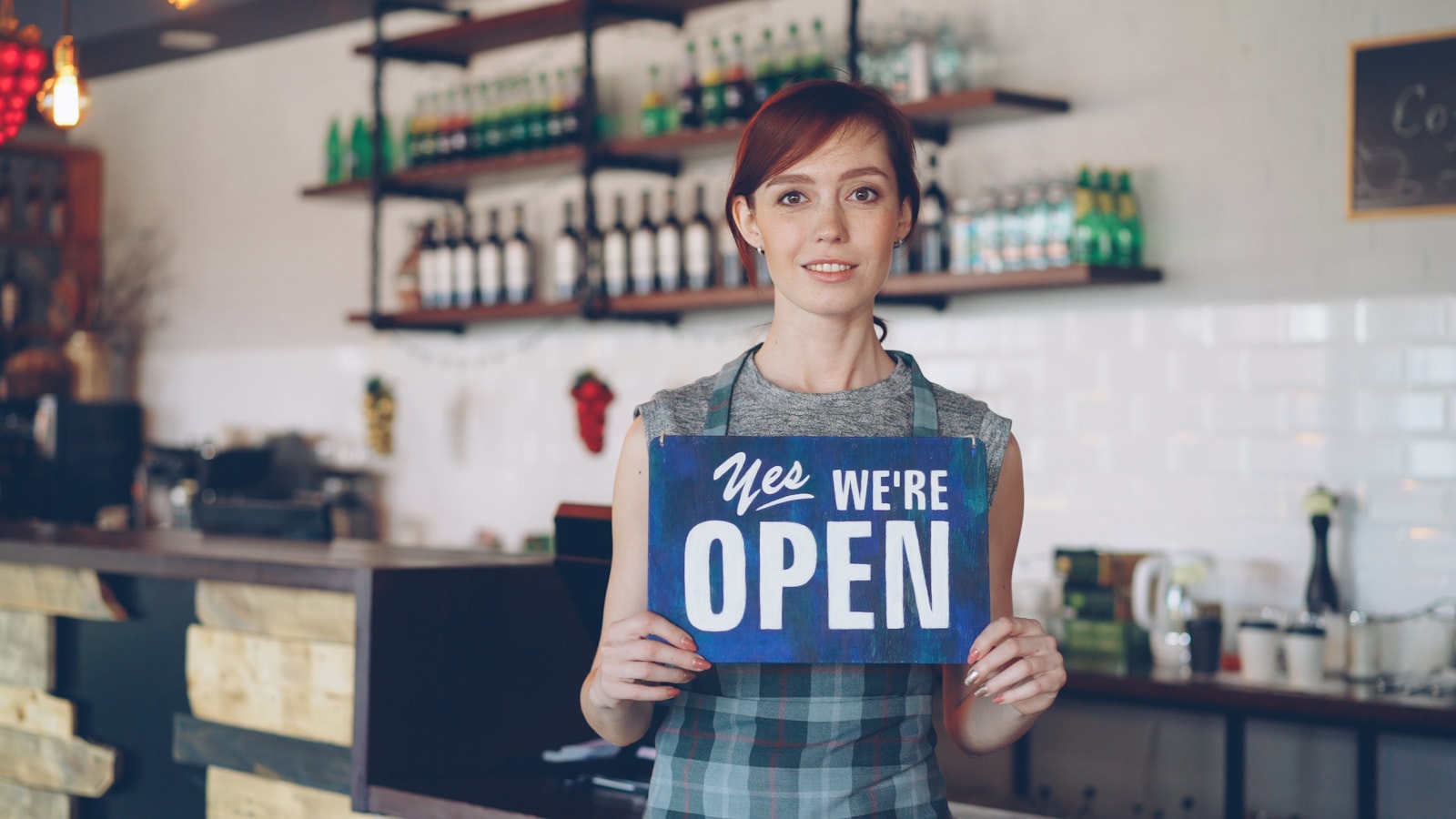 A woman welcoming customers as the shop is open